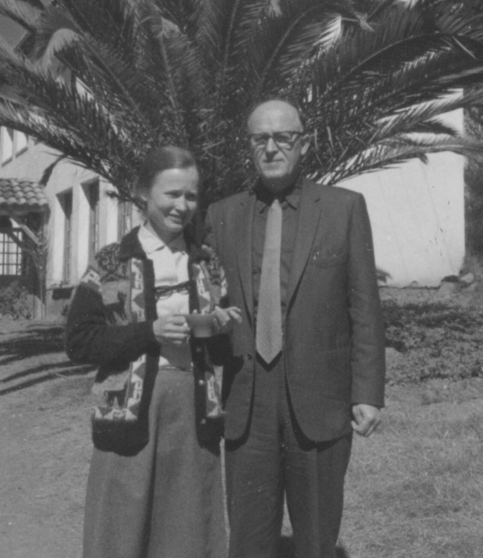 photo of woman and man standing in front of palm tree
