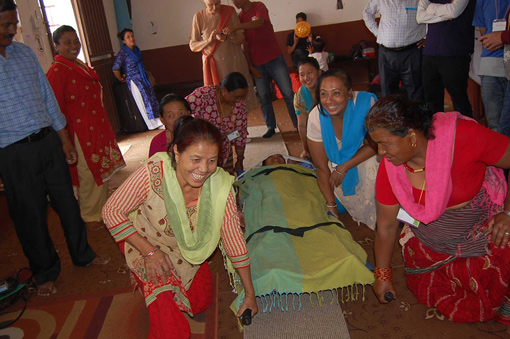 photo of first aid trainees in Nepal learning how to lift a stretcher