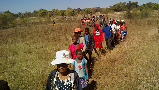people walking single file through field in Madagascar