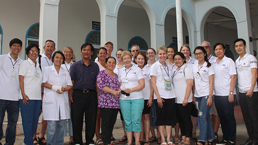 group of Vietnamese people in front of building portico with arches
