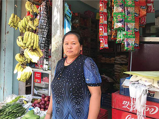 Nepalese woman standing in front of her fruit shop