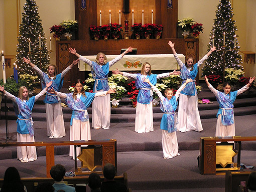photo of young women dancing in front of church altar