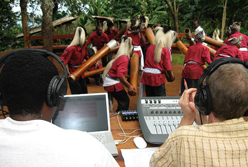 photo of two men recording Tanzanian musicians in jungle