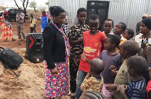 Kenyan woman with group of children outside church building