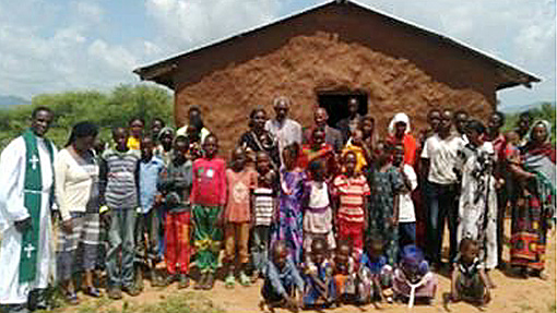 pastor and church members in front of primitive church in Kenya