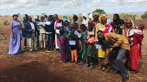 group of people in Kenya holding certificates after baptism