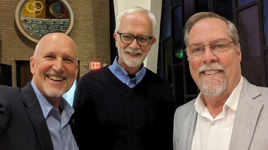 three smiling men with beards