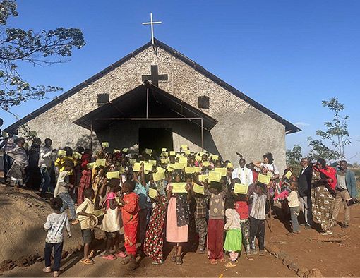 group of African people standing in front of church