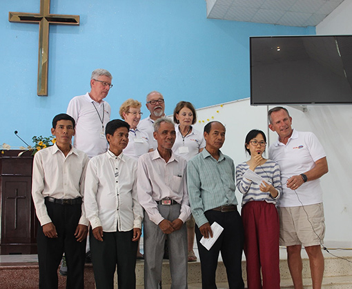 group of Vietnamese people inside church with wood cross on wall