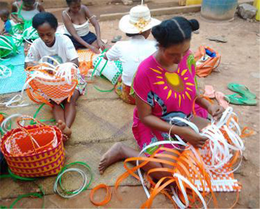 Madagascar women sitting on ground weaving colorful baskets