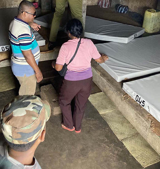 two men and a woman selecting mattresses in warehouse