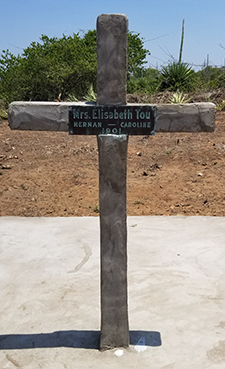 wood cross with name plaque in cemetery