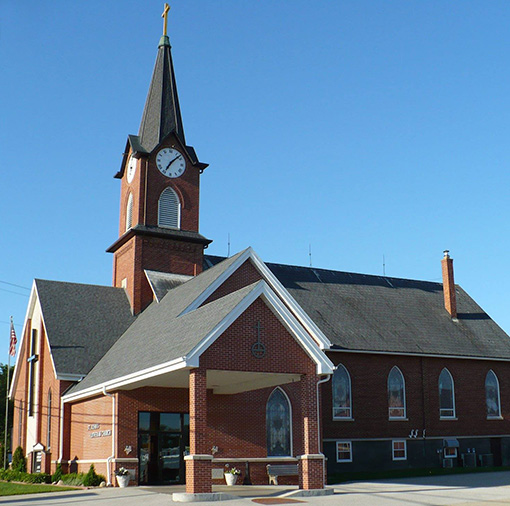 photo of brick church with clock in steeple