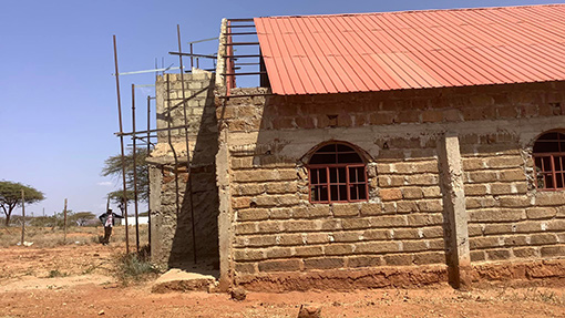 unfinished church building made of mud bricks and orange tin roof in Kenya