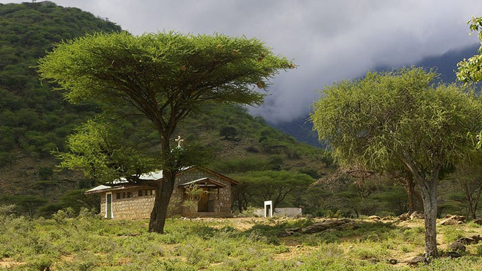 church by baobab tree in Kenya with forests and hills in background