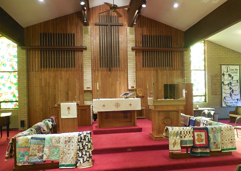 quilt displayed on tables inside church sanctuary