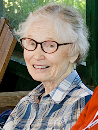 older lady wearing glasses and blue & white plaid shirt