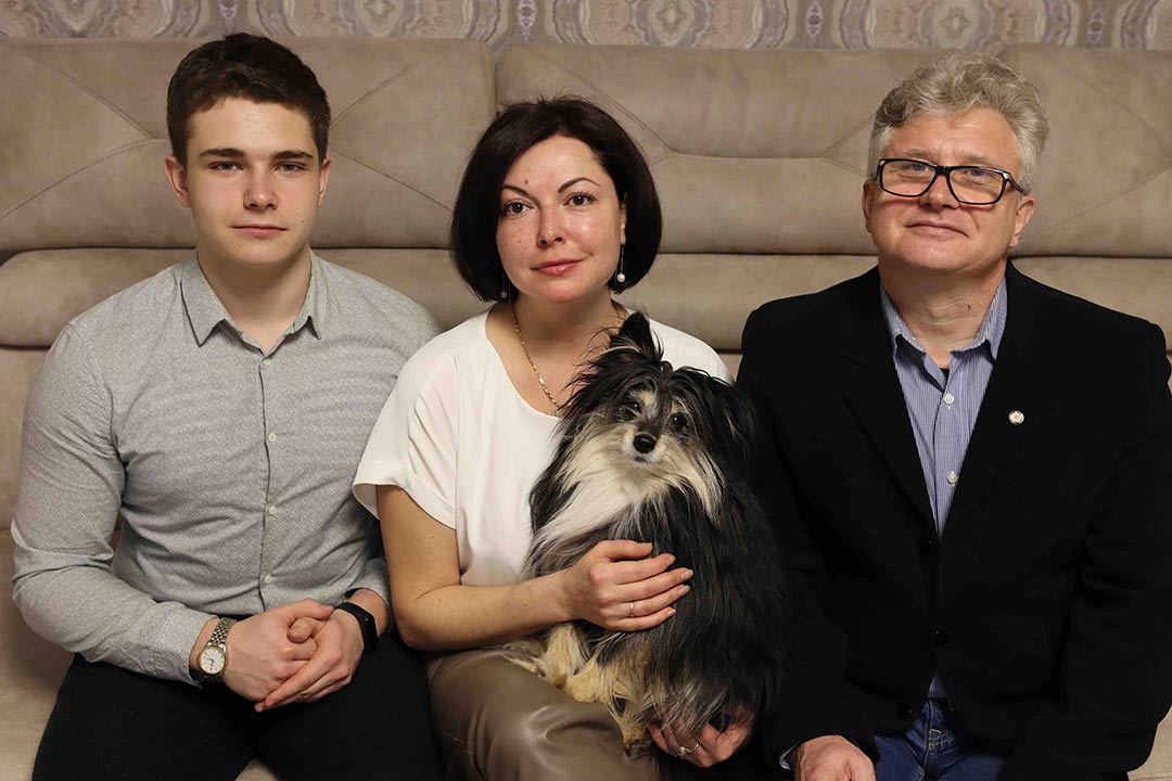 son, mother and father seated on sofa