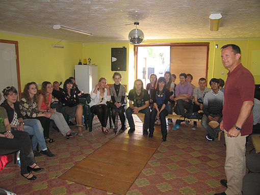 man in room with students seated in semicircle