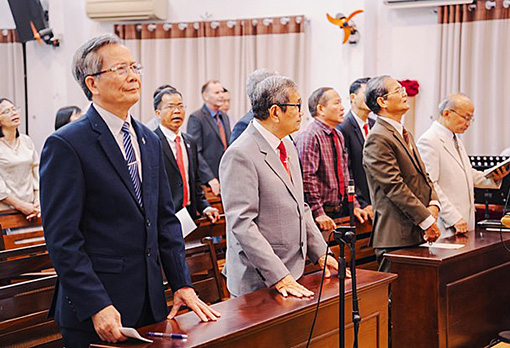 people standing in pews in Vietnamese church
