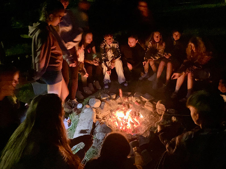 group of youth around campfire at night