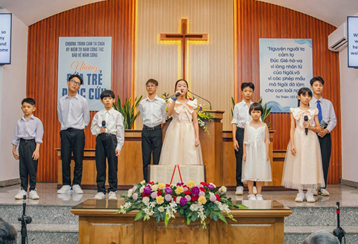 singing children standing on dais in Vietnamese church