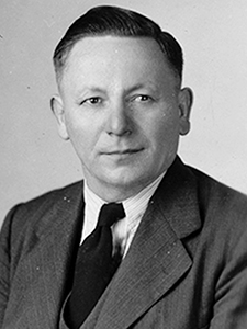 headshot of man wearing suit