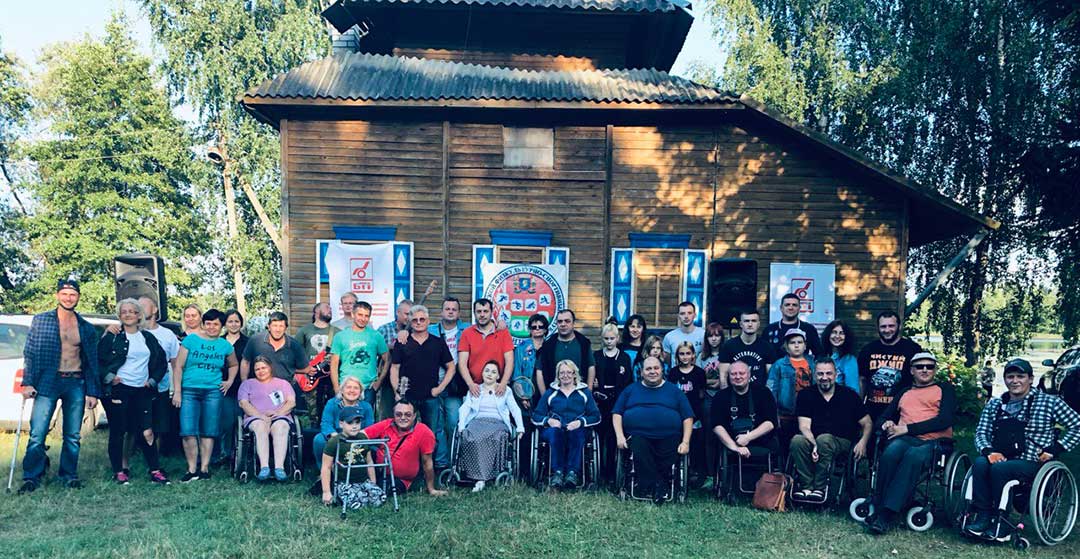 group of disabled people on lawn in front of house