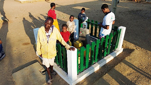 people standing near well enclosure