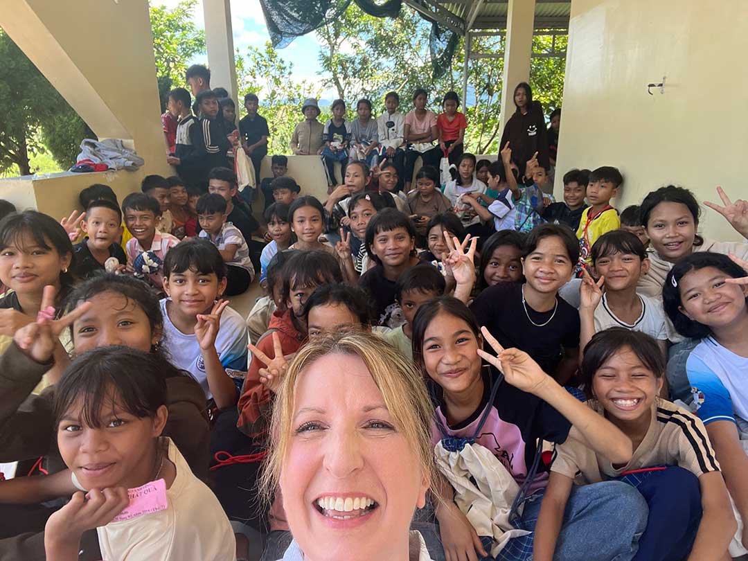 American woman with large group of Vietnamese children