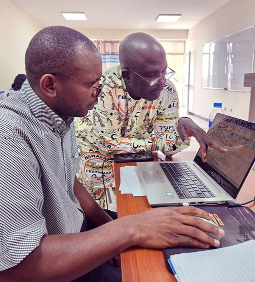 two men looking at laptop computer screen