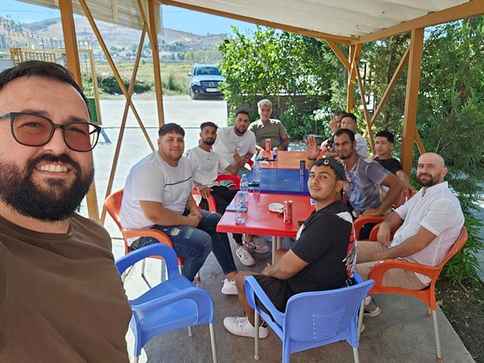 group of men sitting in an outdoor space