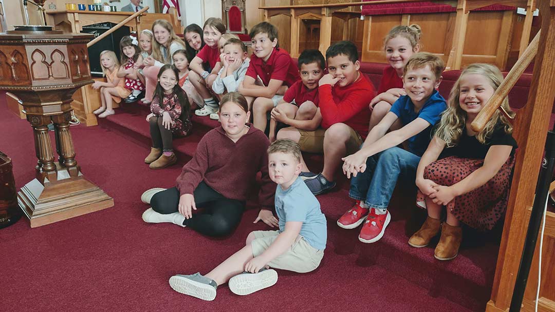 group of children gathered at front of church