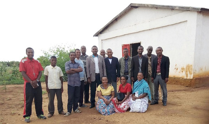 group of people standing in front of white building