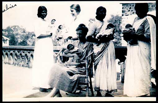 vintage photo of missionaries and helpers caring for babies in India