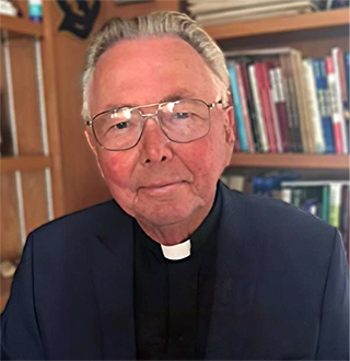 pastor seated in front of bookcase