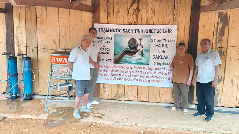 group of Vietnamese men celebrating the installation of a new water system