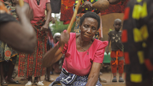 woman wearing pink blouse wielding stick