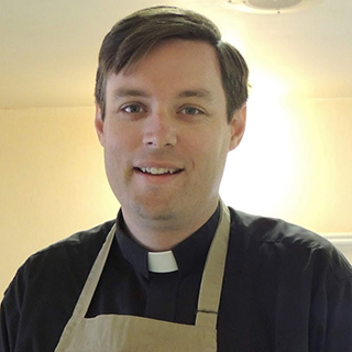 pastor with dark hair wearing apron