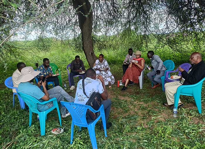 people eating lunch under trees in Kenya