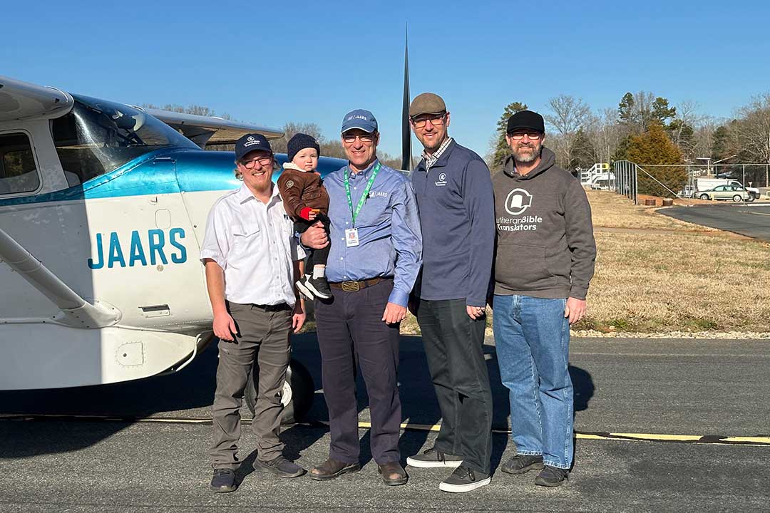 group of men and a child standing by airplane
