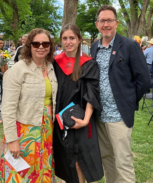 pastor and wife posing for photo with high school graduate