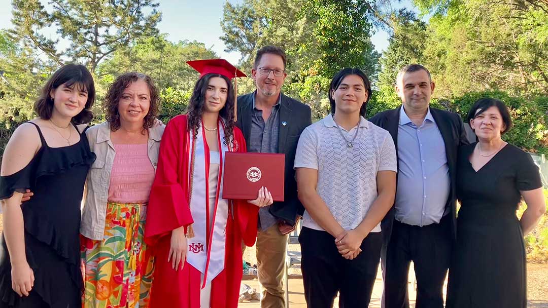 family posing for photo with college graduate