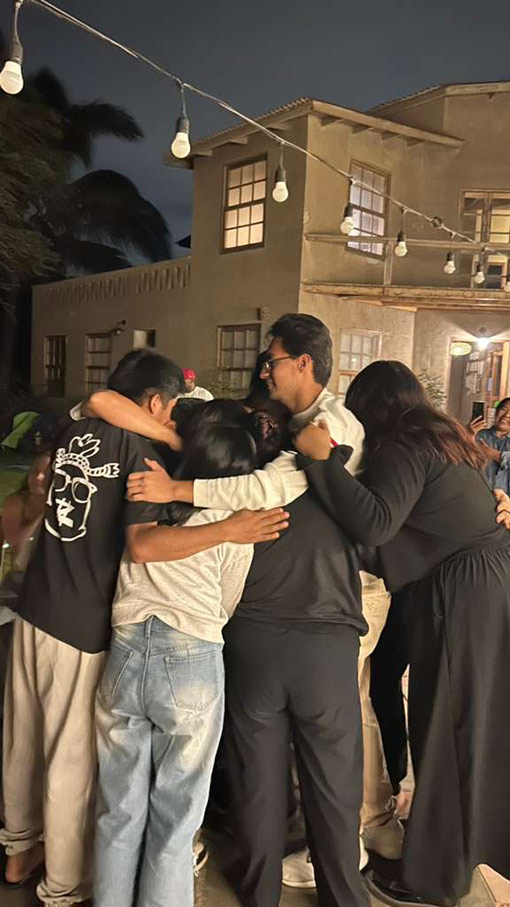 pastor and students praying together on street corner at night