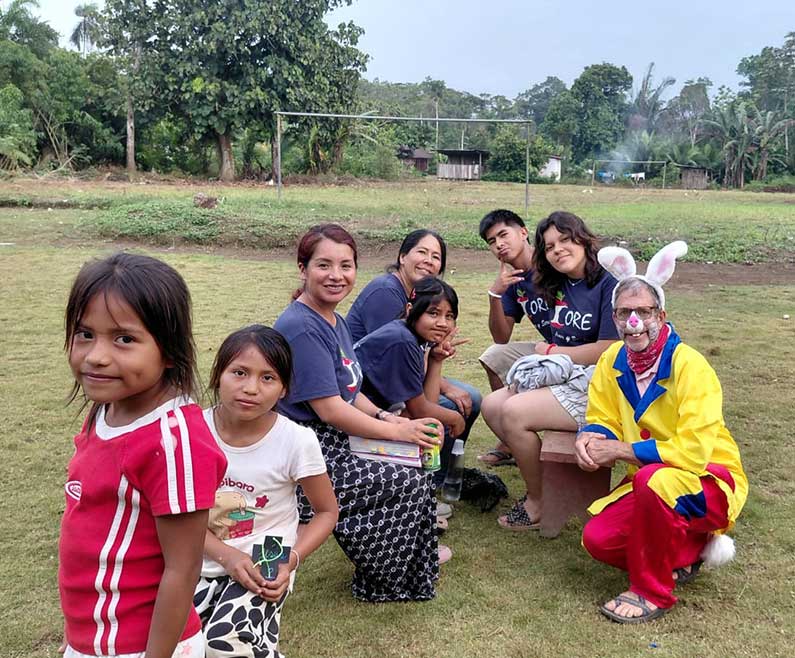 children with mothers and a clown in a village in Indonesia